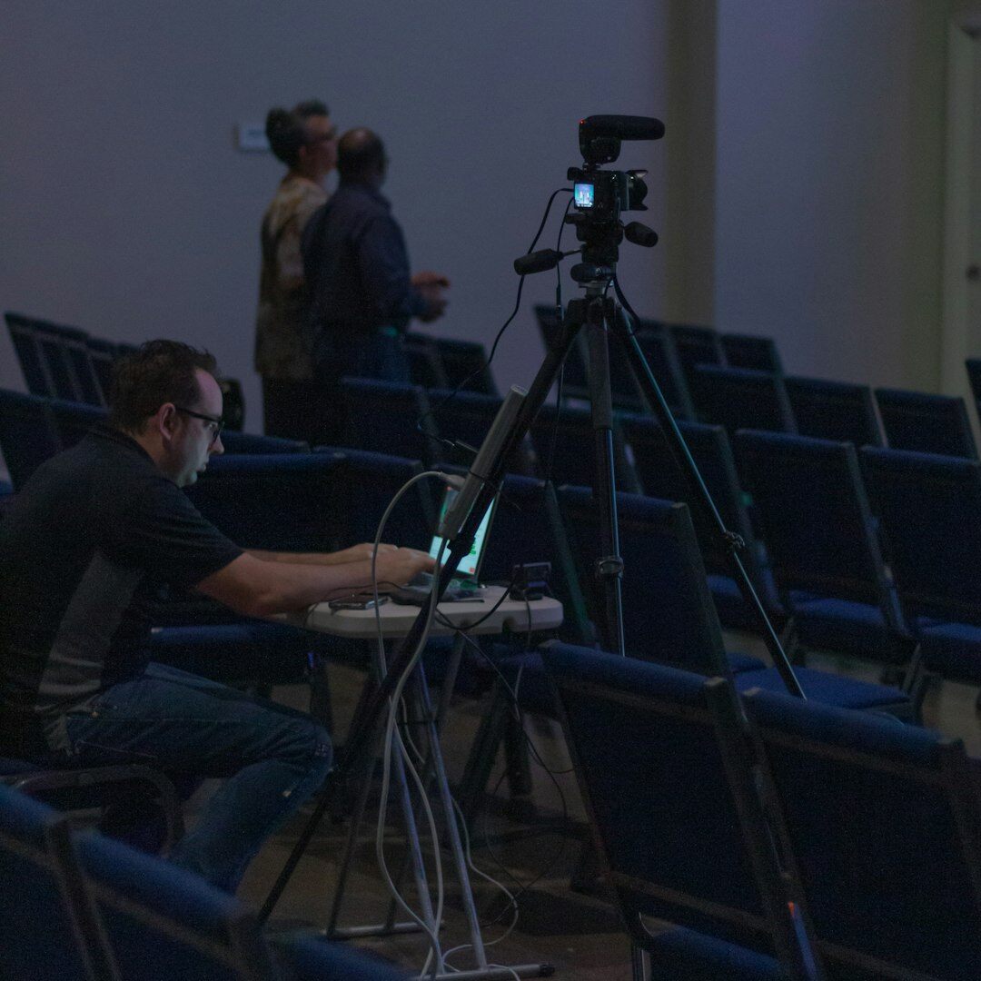 Journaliste tenant un micro devant une caméra en reportage extérieur